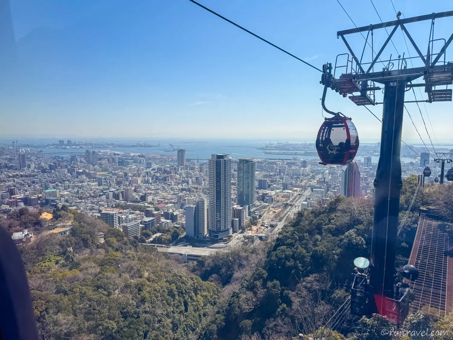 赤いゴンドラが、緑の山と街の風景にアクセントを加えている。